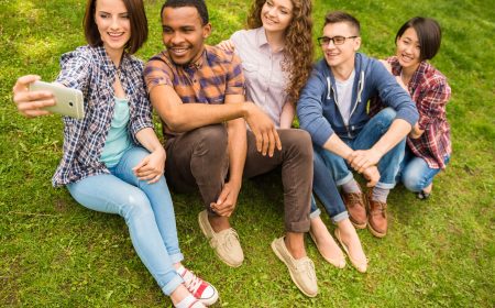 Group of young attractive smiling students dressed casual making selfie outdoors on campus at the university.