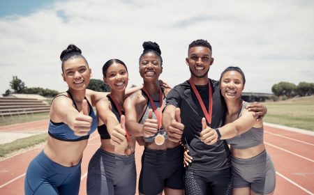 Team, thumbs up and sport winner with medal, runner and happy in portrait, success and win on race .